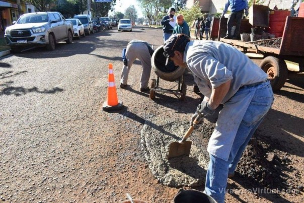 Personal municipal trabaja en la reparación de baches, con concreto de hormigón.